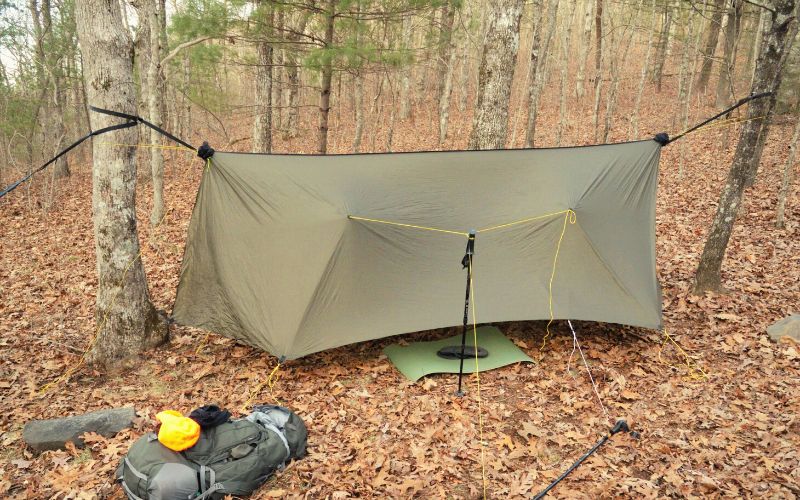 Extra taut tarp setup over hammock hung between two trees