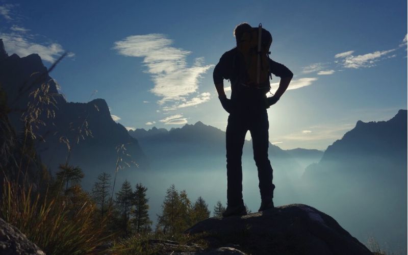 Silhouette of hiker standing on a mountaintop