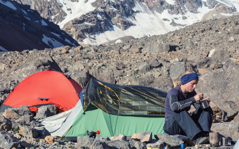 Climber camping out with a tent and a bivy both pitched beside her