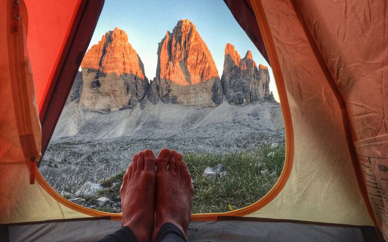 View of mountains and feet from inside a tent