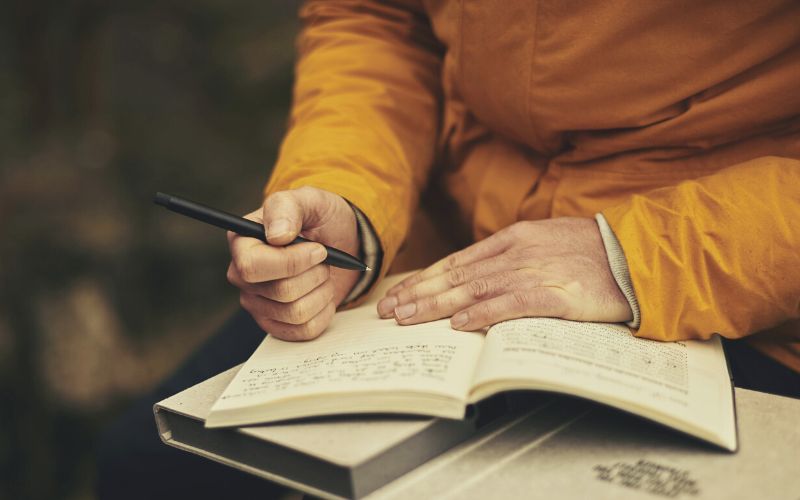 Backpacker writing in a journal