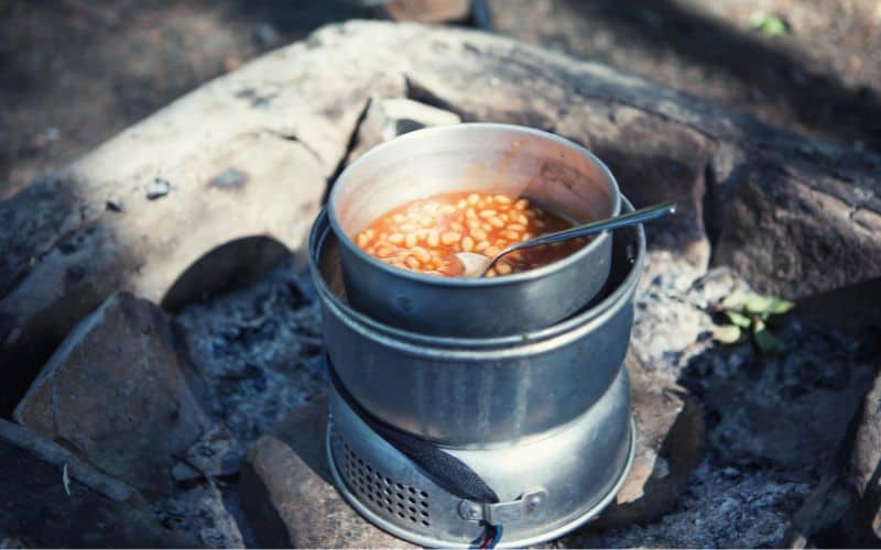 Beans cooking in a pan on a camping stove