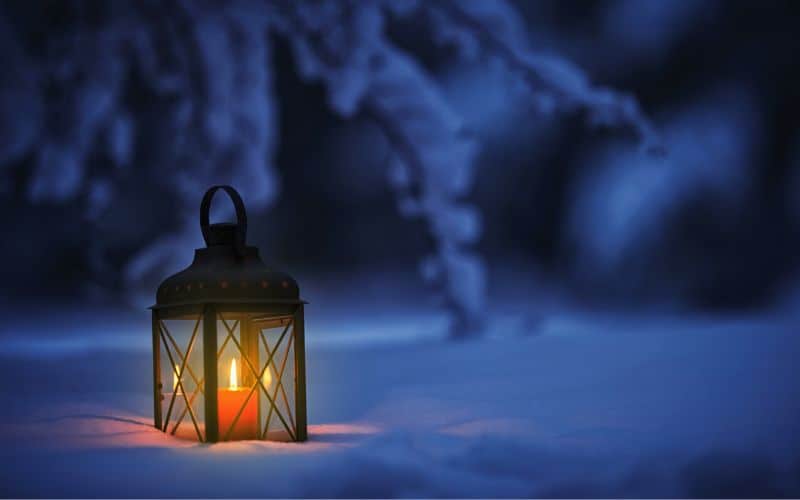 Candle lantern sitting in the snow