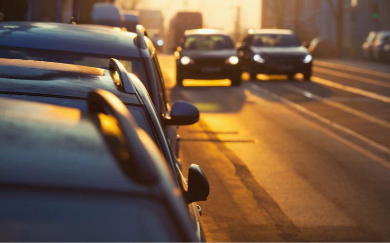 Cars parked at side of road at sunrise