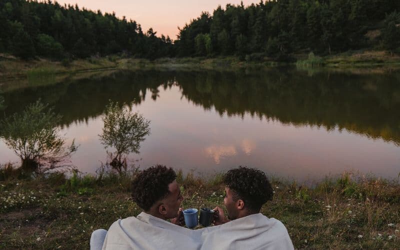 Couple under a blanket in front of a lake