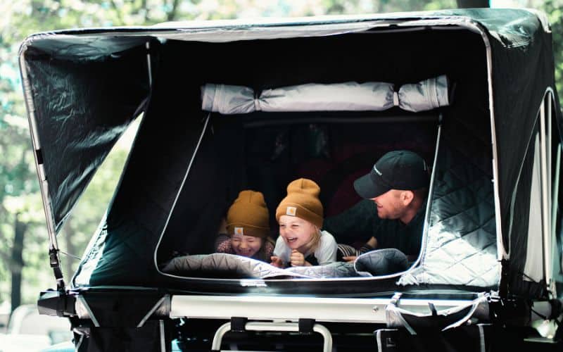 Dad and his kids playing a game in their tent