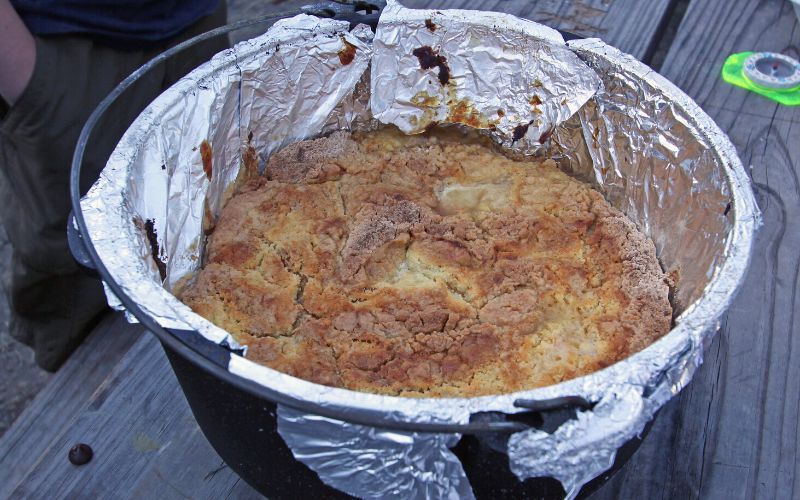 Dutch oven peach cobbler on camping table