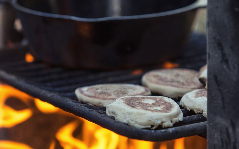 English muffins toasting over campfire