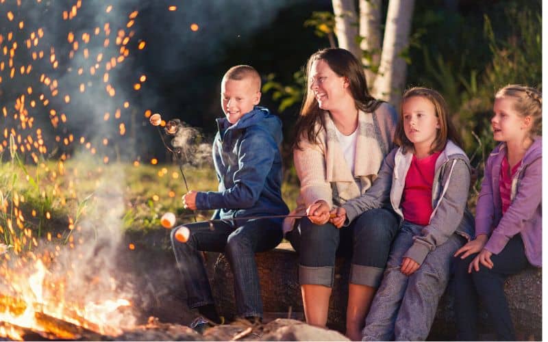 Family playing truth or dare with a kid burning a marshmallow