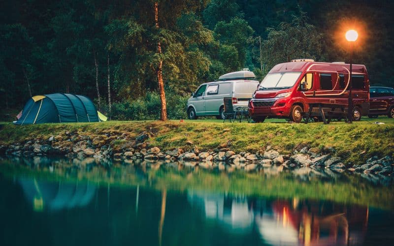 Campervans and tent at the waterside