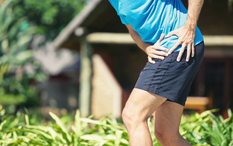 Hiker holding  their hip in pain