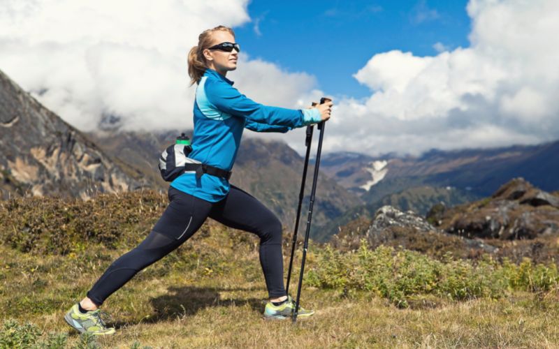 Hiker stretching legs in front of a mountain landscape