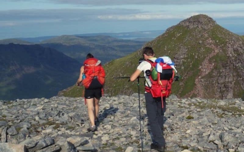 Hikers carrying their sleeping bags on their backpacks in different ways