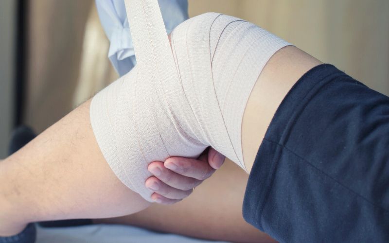 Person getting knee bandaged by a doctor