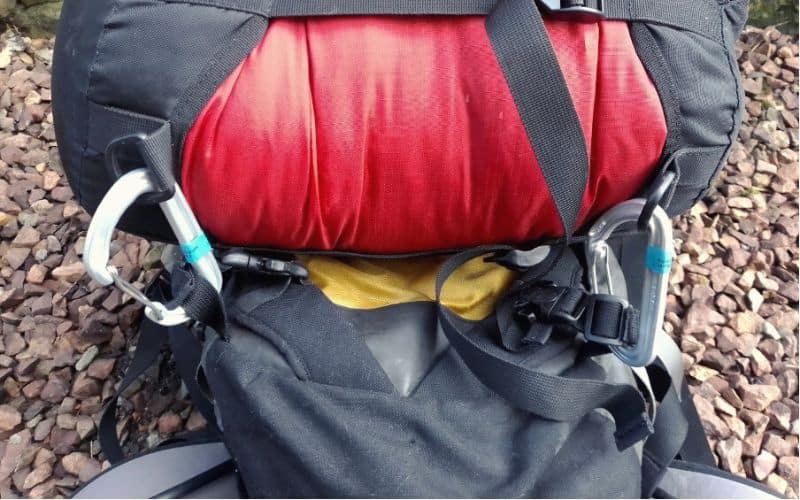 Sleeping bag attached to backpack with backpack gear loops