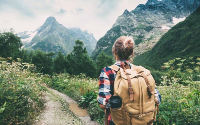 Solo hiker walking on trail through mountains