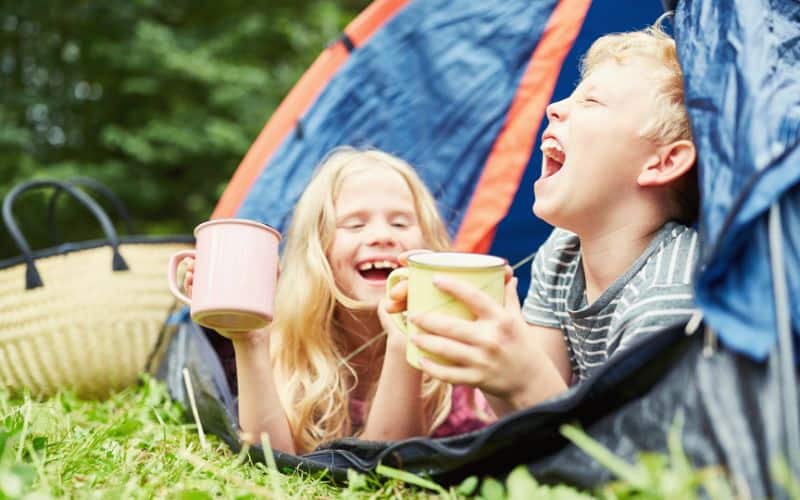 Two kids laughing in their tent