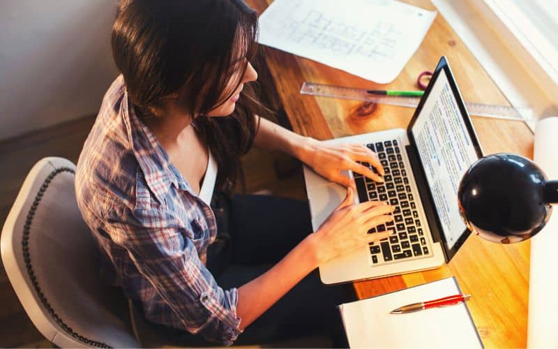 Writer typing on her laptop at a desk