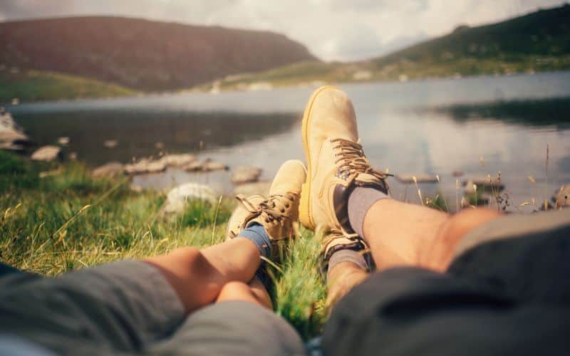 Couple of hikers legs in front of a lake