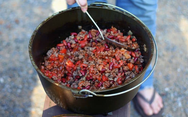 Camper stirring ready to eat campfire chili