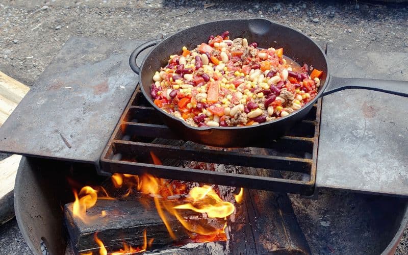 Chili cooking over a fire in a drum