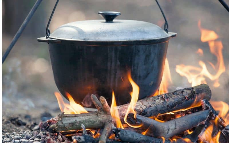 Dutch oven with lid on sitting over a campfire