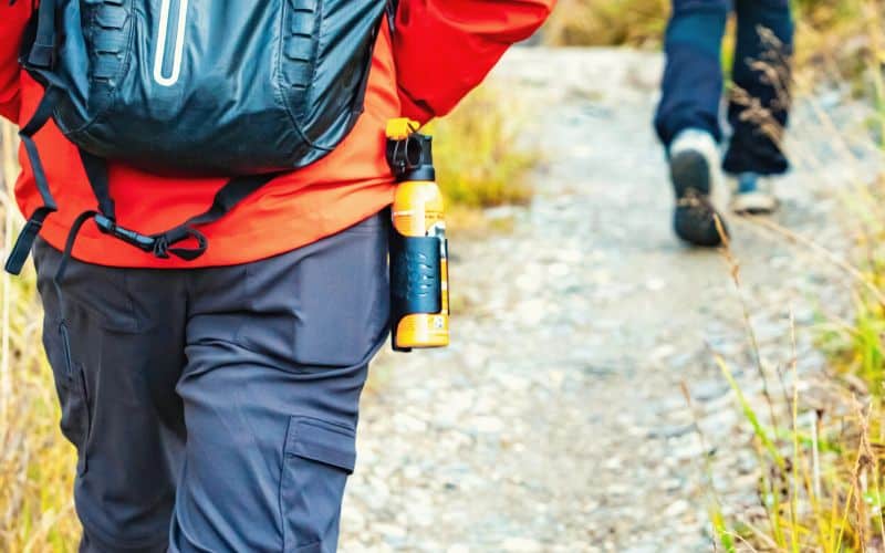 Hiker carrying bear spray on belt