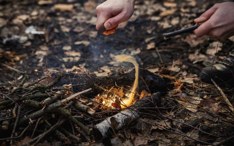 Man starts a fire using a flint and knife