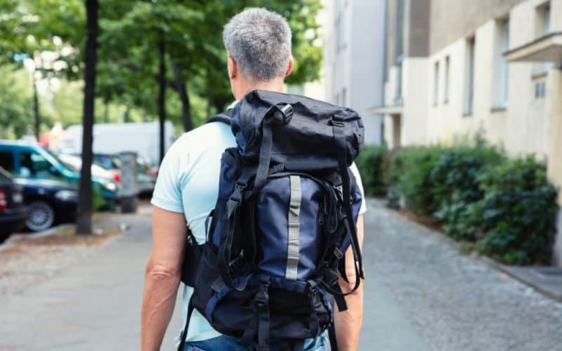 Man wearing hiking backpack around a city