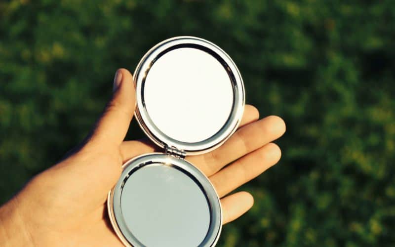 Small handheld mirror reflecting the sun