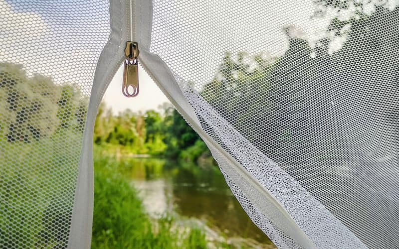 The zip on a tent mosquito net being closed