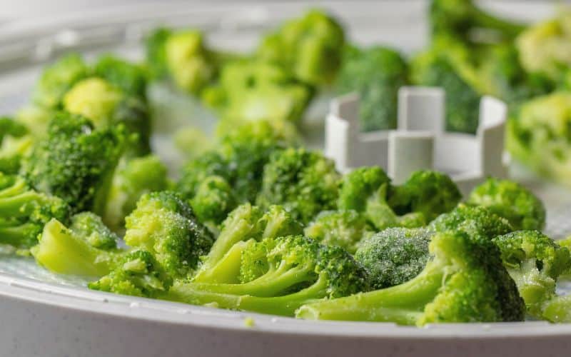 Broccoli florets sitting on dehydrator tray