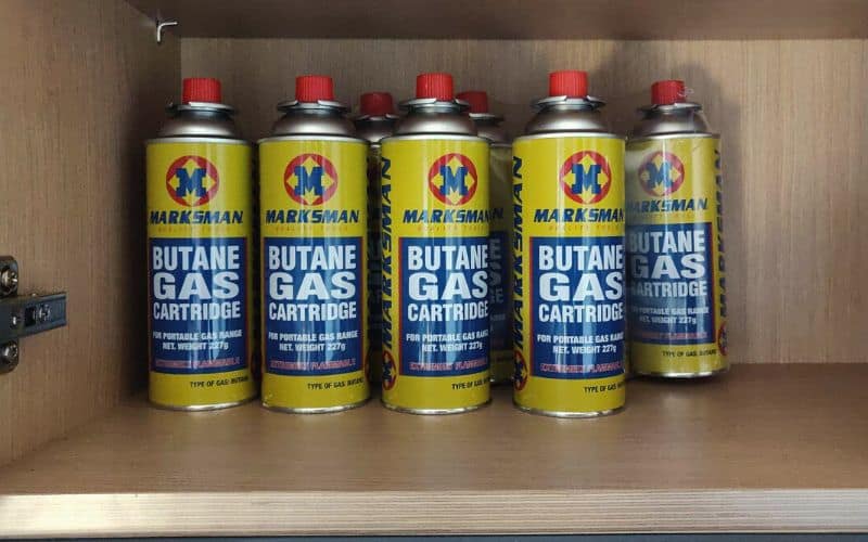 Butane gas canisters stored in a cool, dark cupboard 