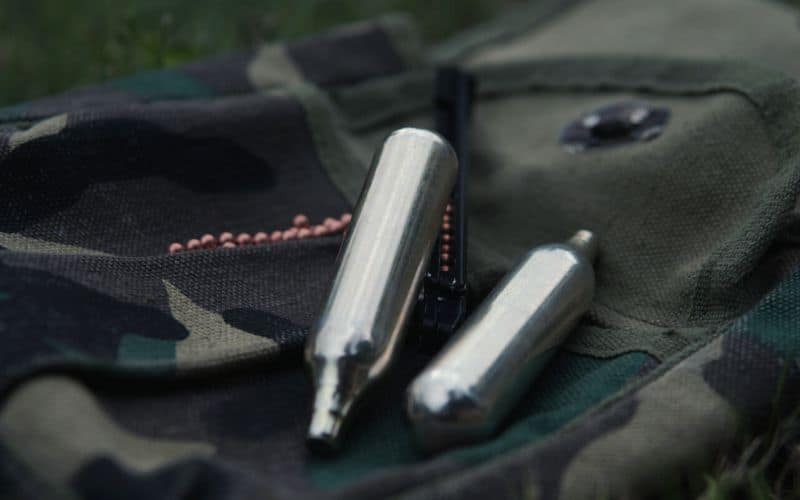 CO2 cartridges lying on a camouflage bag 