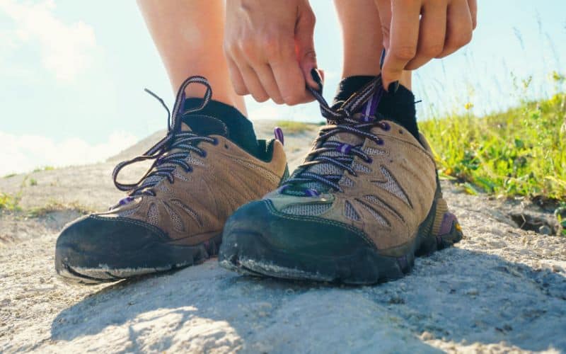 Close up of hiker tying hiking shoes with mesh panels
