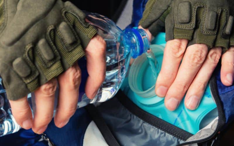 Person filling hydration pack with water