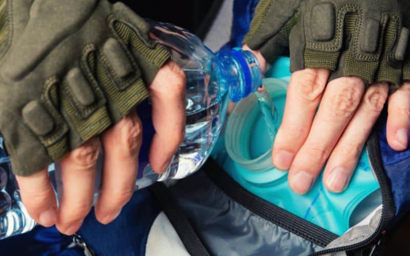 Person filling hydration pack with water