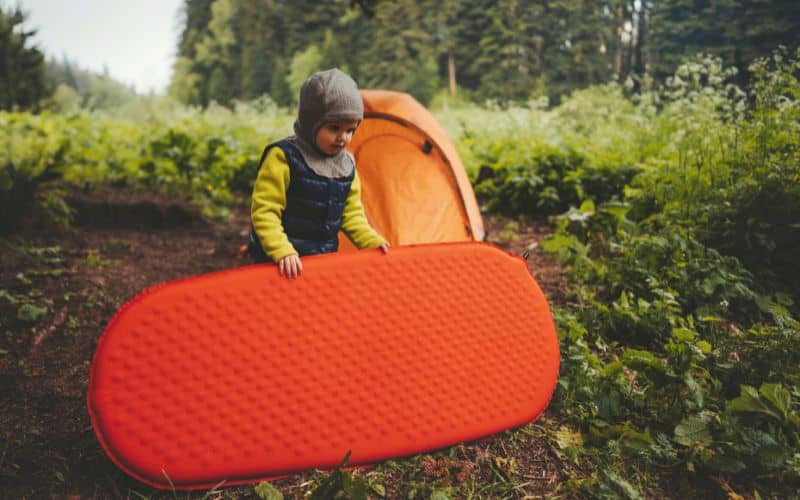 Child carrying a child's sleeping pad