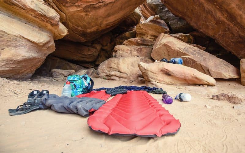 Inflatable sleeping pad set up on a sandy surface