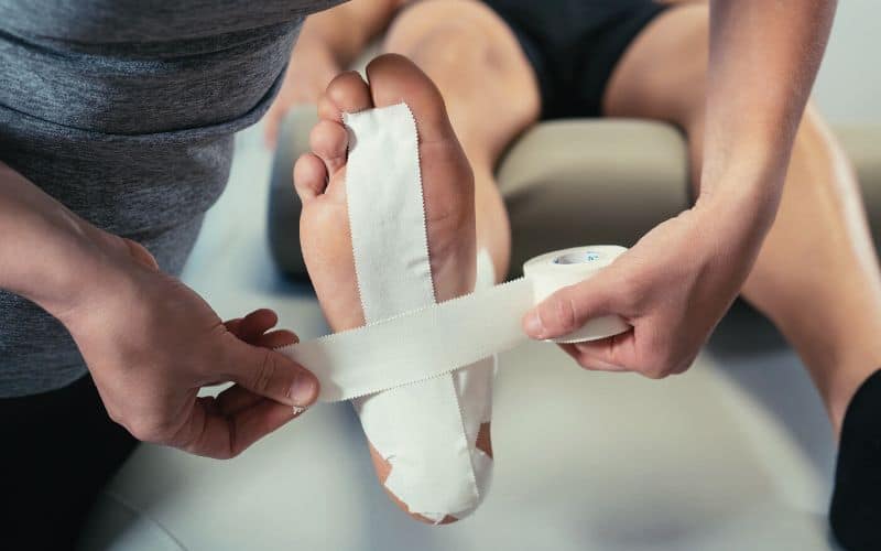 Physio putting medical tape on patients foot