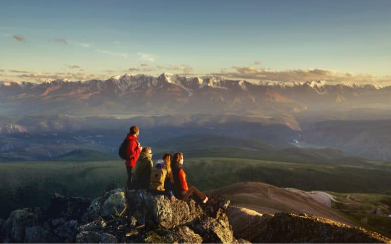 Hiking friends on top of mountain watching the sunset