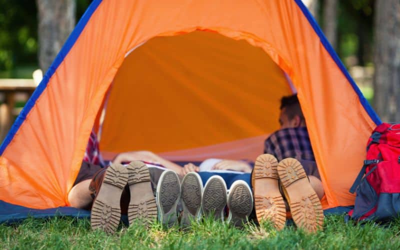Family of four with their feet sticking out of their tent