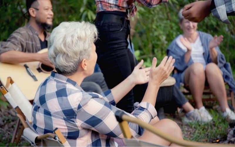 Group of people clapping and dancing to a guitar being played