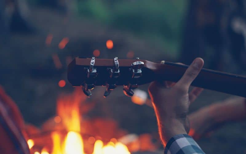 Guitar neck in front of a campfire
