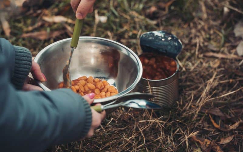 Campers preparing to heat baked beans