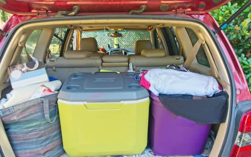 Car trunk filled with camping items and cooler