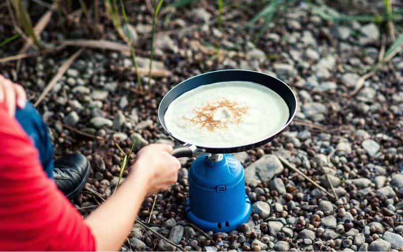 Cooking pancakes over a camp stove 