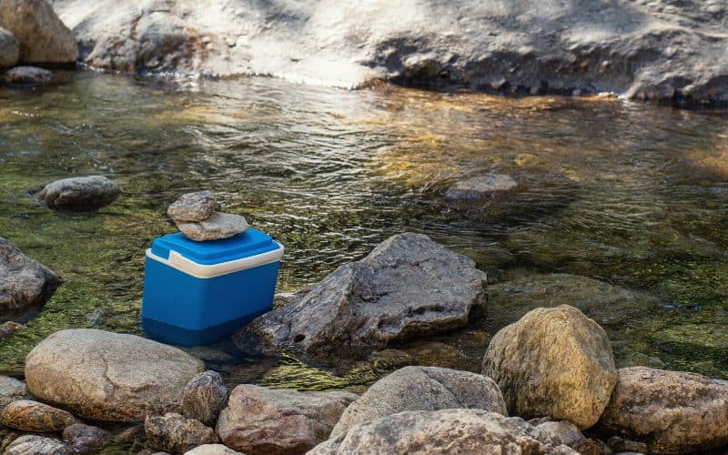 Ice cooler sitting in river to keep cool