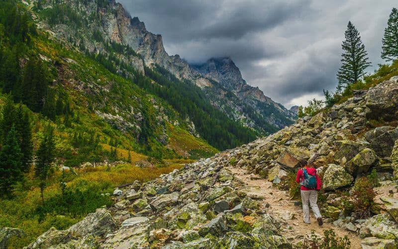 Woman hiking through Cascade Canyon on the Teton Crest Trail