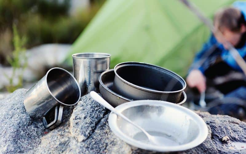 Dishes air drying in front of a tent